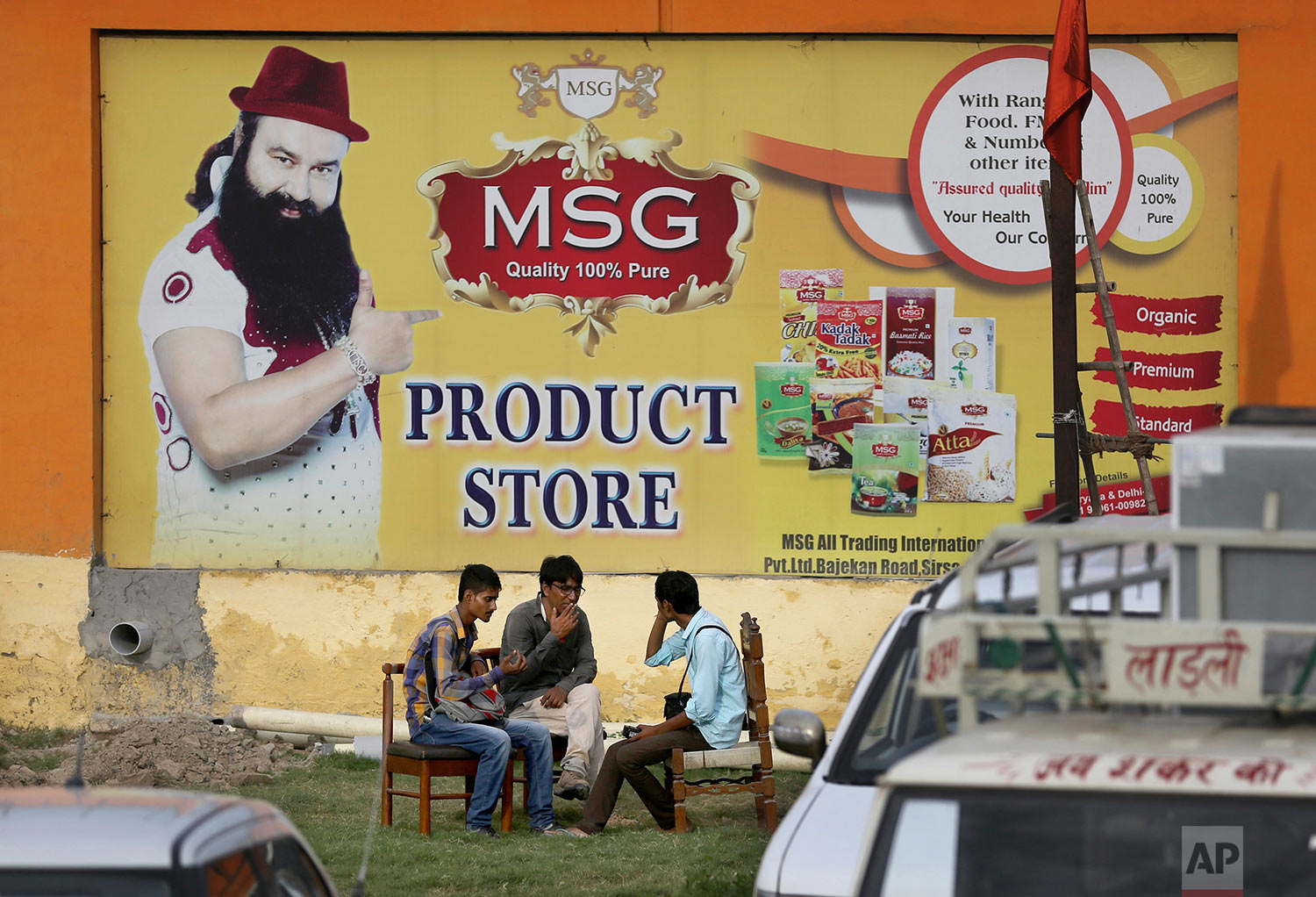  People sit outside the store belonging to Dera Sacha Sauda sect chief Gurmeet Ram Rahim Singh after it was closed down by authorities near Sonipat, India, Saturday, Aug. 26, 2017. (AP Photo/Altaf Qadri) 