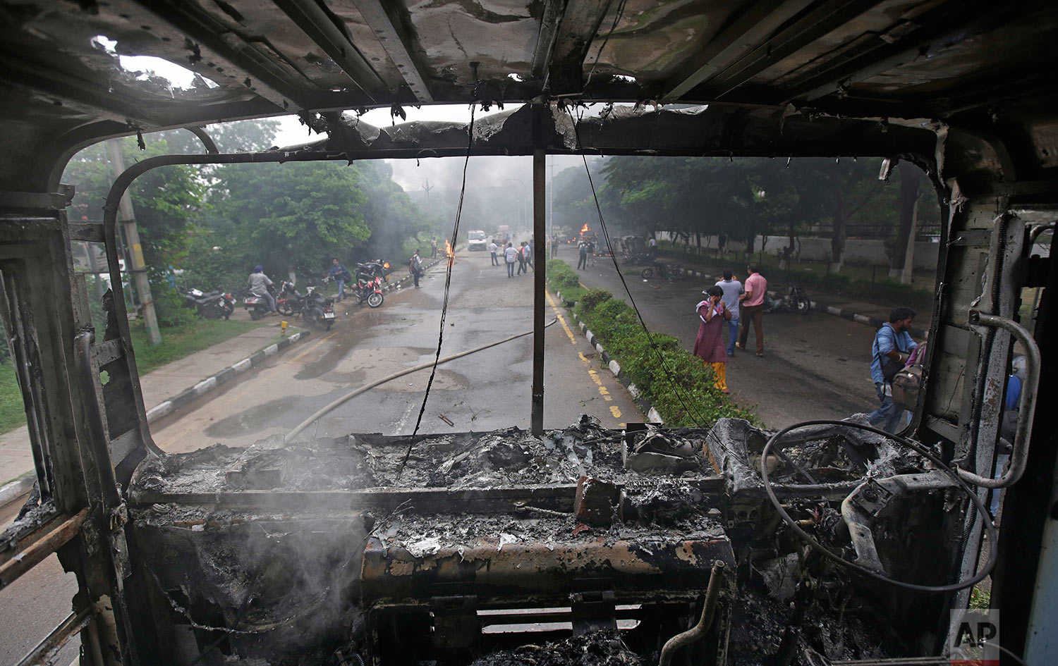  In this Friday, Aug. 25, 20917 photo, a fire brigade truck burned by Dera Sacha Sauda sect members lies near Panchkula's court house, India. Deadly riots have broken out in a north Indian town after a court convicted a guru of raping two of his foll