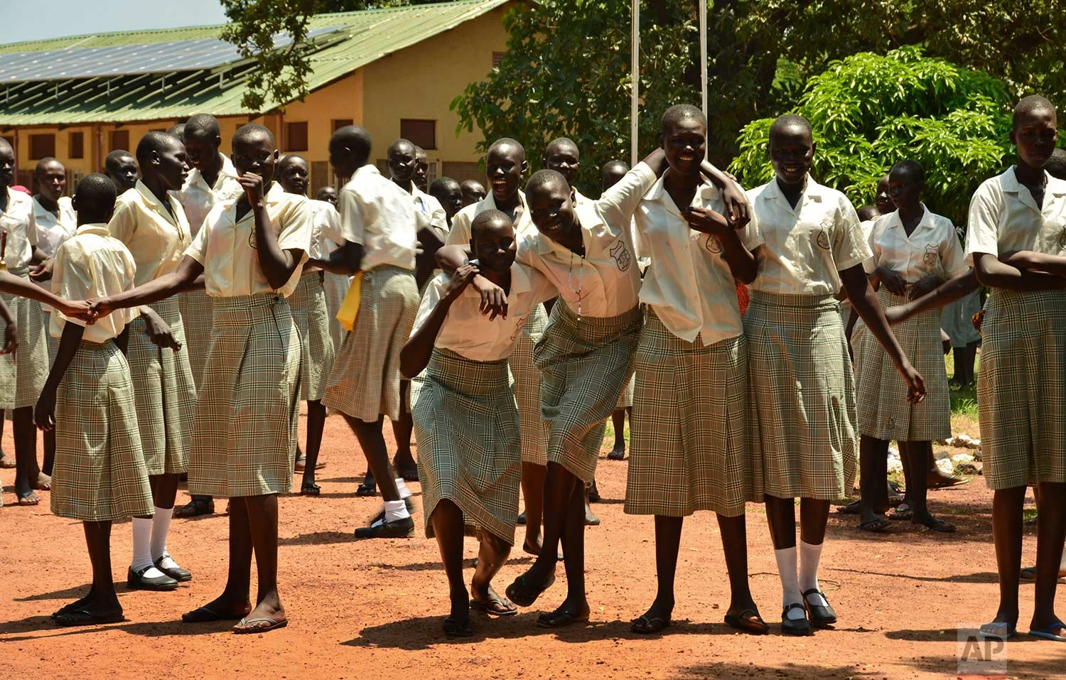 In this photo taken Sunday, July 30, 2017, girls take a break at the Irish-run Loreto Secondary School, the region's only all-girls boarding school where staff require each girl's guardian to sign a form promising not to remove the child from school until graduation, in the town of Rumbek, South Sudan. (AP Photo/Mariah Quesada)