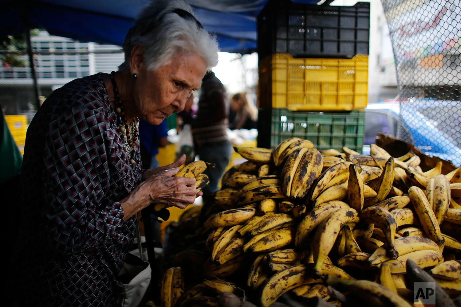 A woman pick out plantains at a market, Aug. 23, 2017, Caracas, Venezuela. (AP Photo/Ariana Cubillos)