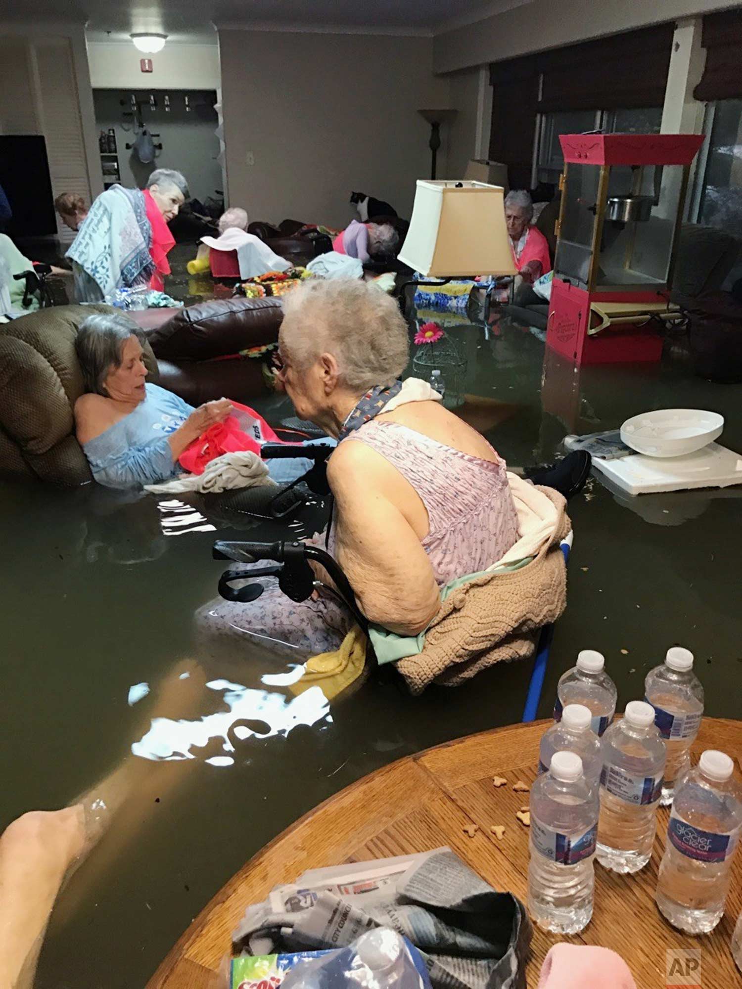  In this photo provided by Trudy Lampson, residents of the La Vita Bella nursing home in Dickinson, Texas, sit in waist-deep flood waters caused by Hurricane Harvey on Sunday, Aug. 27, 2017. Authorities said all the residents were safely evacuated fr