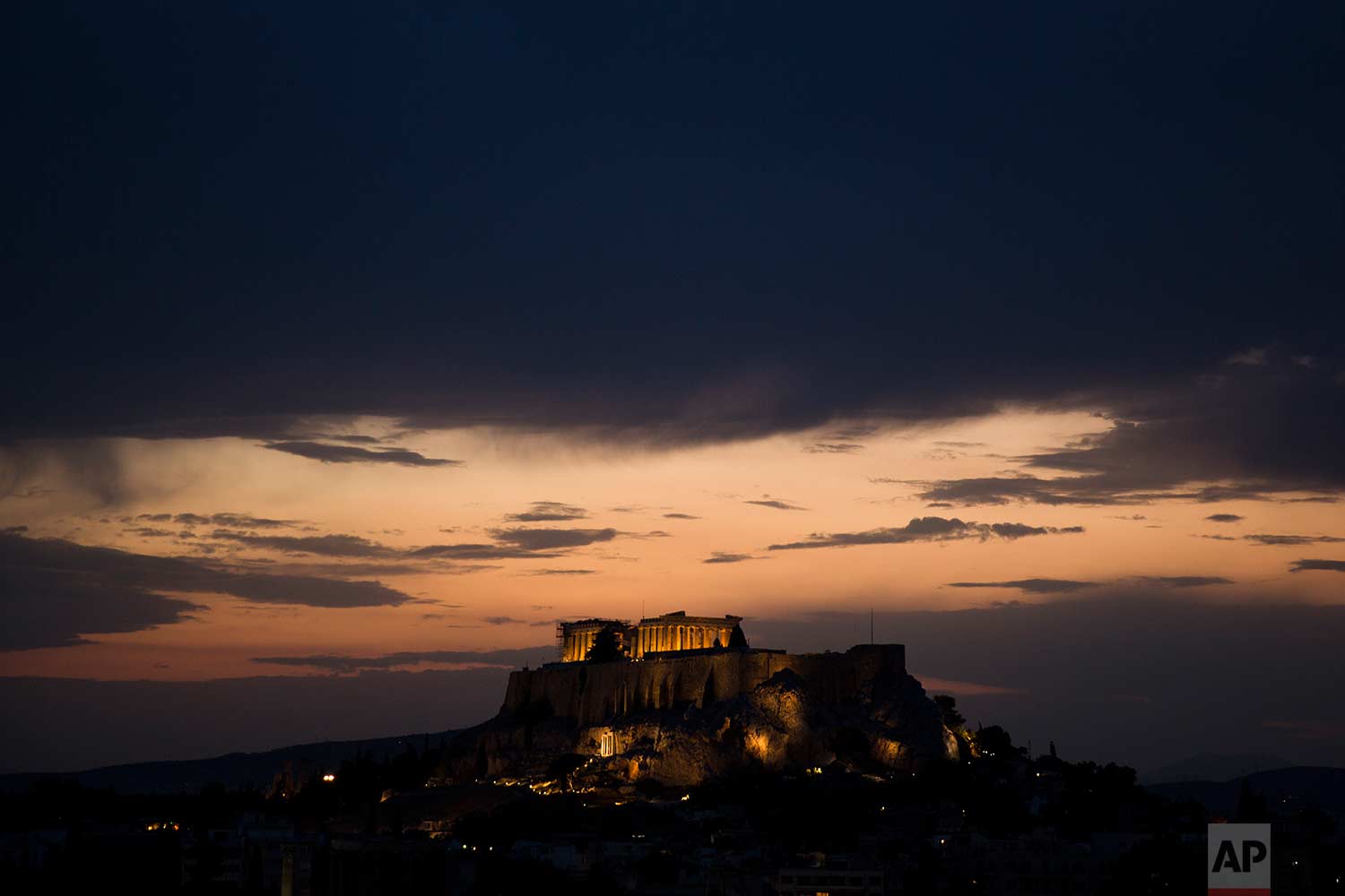  Clouds cover the Athenian sky as the ancient Acropolis hill and the ruins of the fifth century B.C. Parthenon temple are illuminated on Tuesday, Aug. 29, 2017. (AP Photo/Petros Giannakouris) 