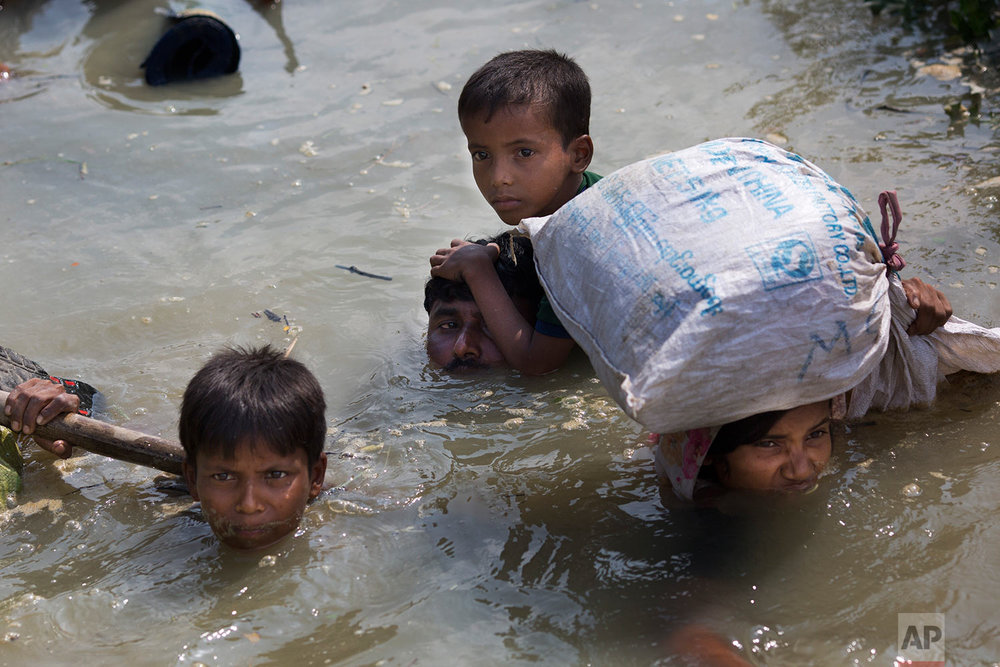  A Rohingya family reaches the Bangladesh border after crossing a creek of the Naf river on the border with Myanmmar, in Cox's Bazar's Teknaf area, Tuesday, Sept. 5, 2017. (AP Photo/Bernat Armangue) 