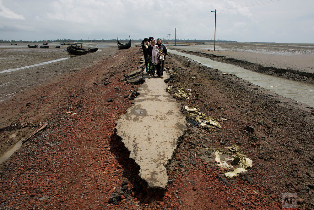  Myanmar's Rohingya ethnic minority family members walk on a broken road a day after crossing over to the Bangladesh side of the border near Cox's Bazar's Dakhinpara area, Saturday, Sept. 2, 2017. Thousands of Rohingya Muslims are pouring into Bangla