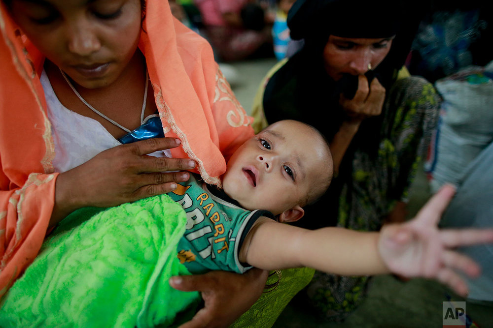  Rohingya woman Rahima, left, sits with her six months old child Jewel at a temporary shelter after being detained by Bangladeshi border guards while crossing the Naf River to enter Bangladesh at Shah Porir Deep, in Teknak, Bangladesh, Thursday, Aug.