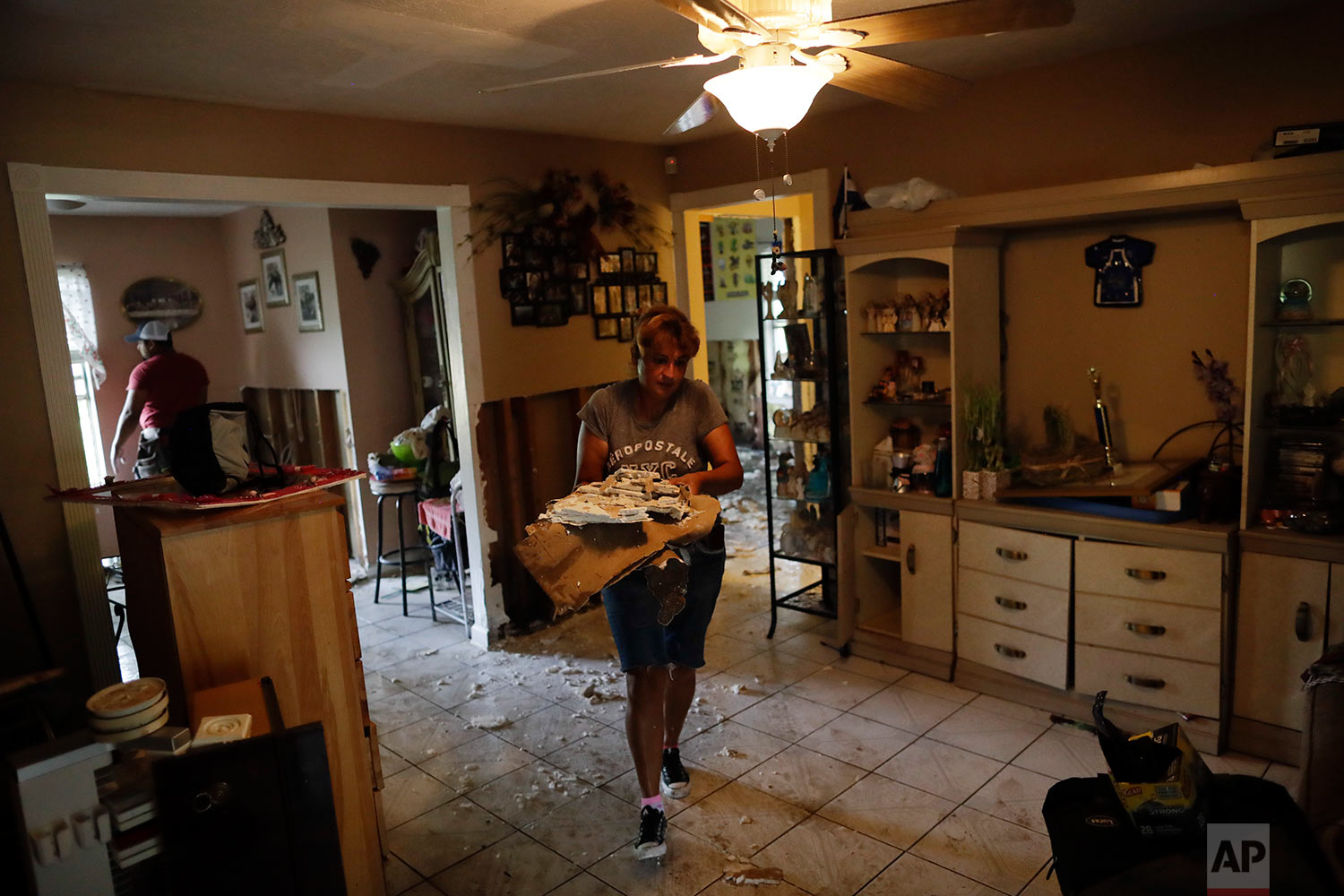  In this Sunday, Sept. 3, 2017, photo, Ana Benavidez carries sections of damaged drywall as she cleans out her flooded home in Houston. (AP Photo/Gregory Bull) 