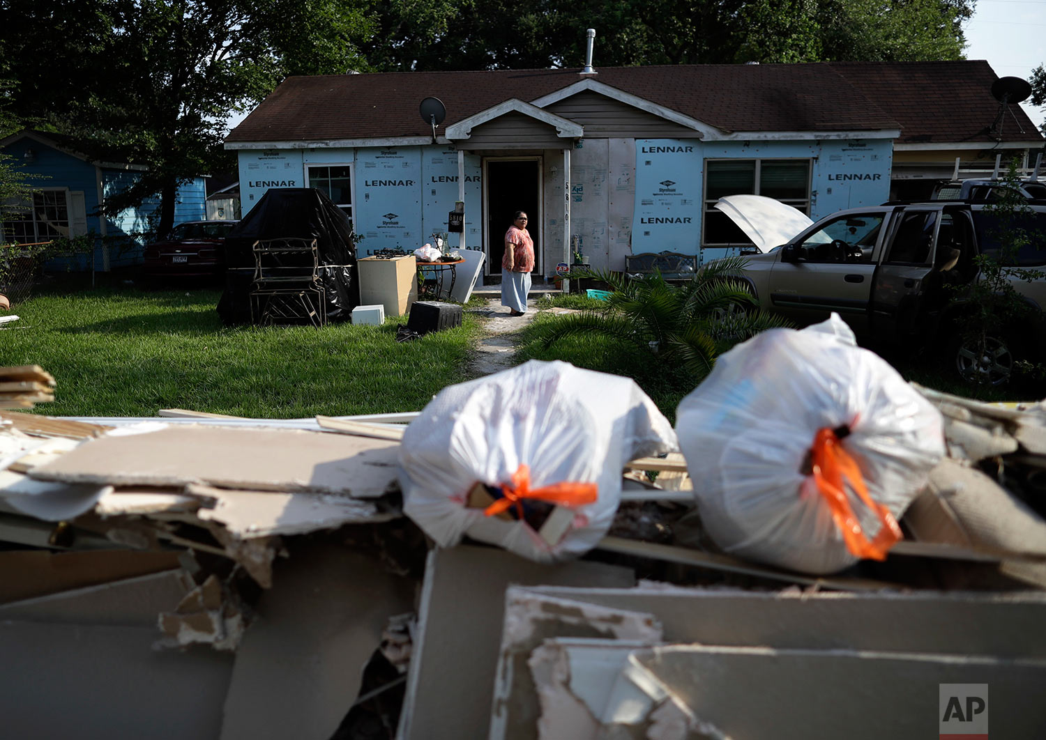  In this Sunday, Sept. 3, 2017, photo, Griselda Perez looks out from behind a wall of flood-damaged debris as the family cleans out their flooded home Sunday, Sept. 3, 2017, in Houston.  (AP Photo/Gregory Bull) 