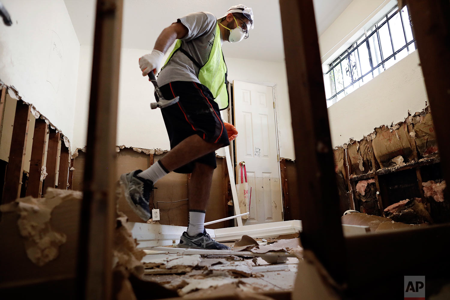  In this Sunday, Sept. 3, 2017, photo, volunteer Hashir Ayubi, of the the Ahmadiyya Muslim Youth Association helps clean out a flood-damaged home in Houston.  (AP Photo/Gregory Bull) 