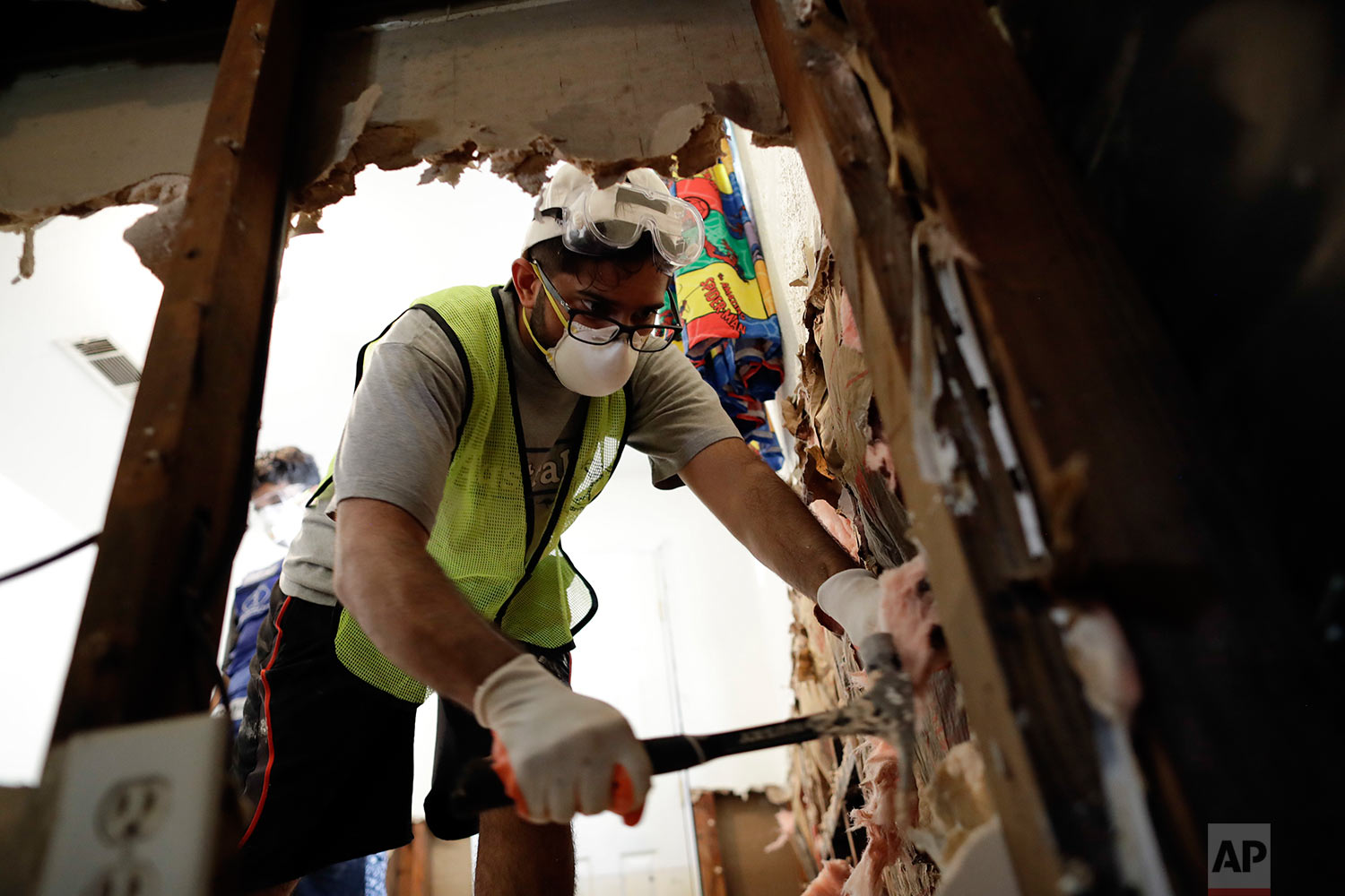  In this Sunday, Sept. 3, 2017, photo, volunteer Hashir Ayubi, of the the Ahmadiyya Muslim Youth Association helps clean out a flood-damaged home in Houston. (AP Photo/Gregory Bull) 