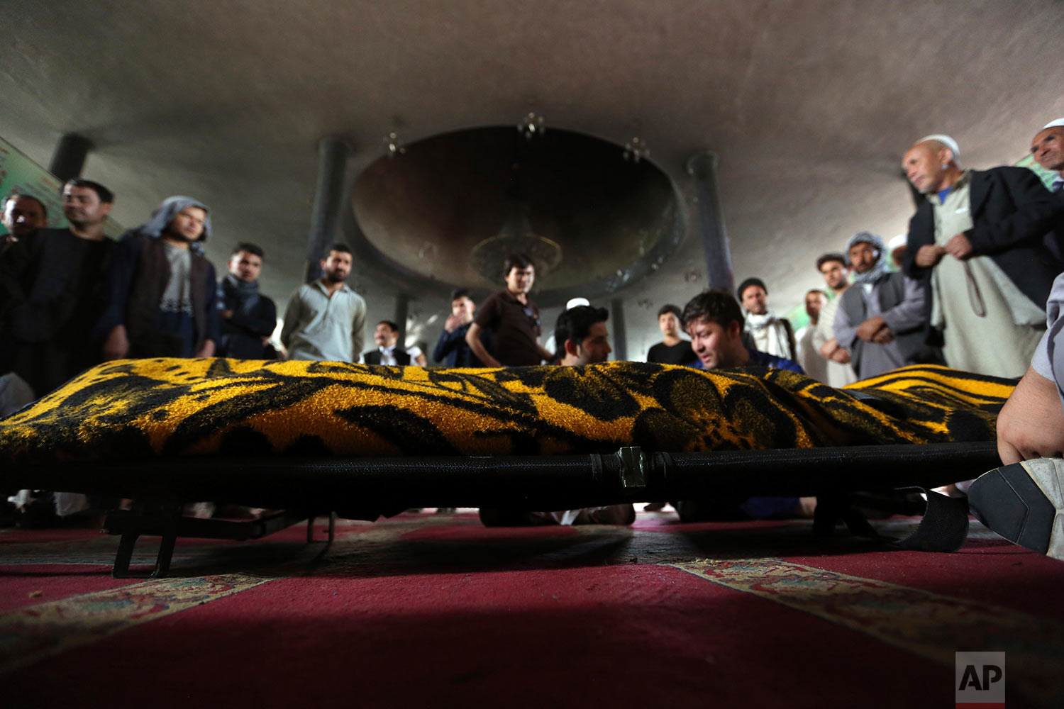  Men stand near the coffin of a relative who died in a Shiite mosque attack, Saturday, Aug. 26, 2017, in Kabul, Afghanistan. Dozens of people, including women and children, were killed in an attack on a Shiite mosque in the Afghan capital during Frid