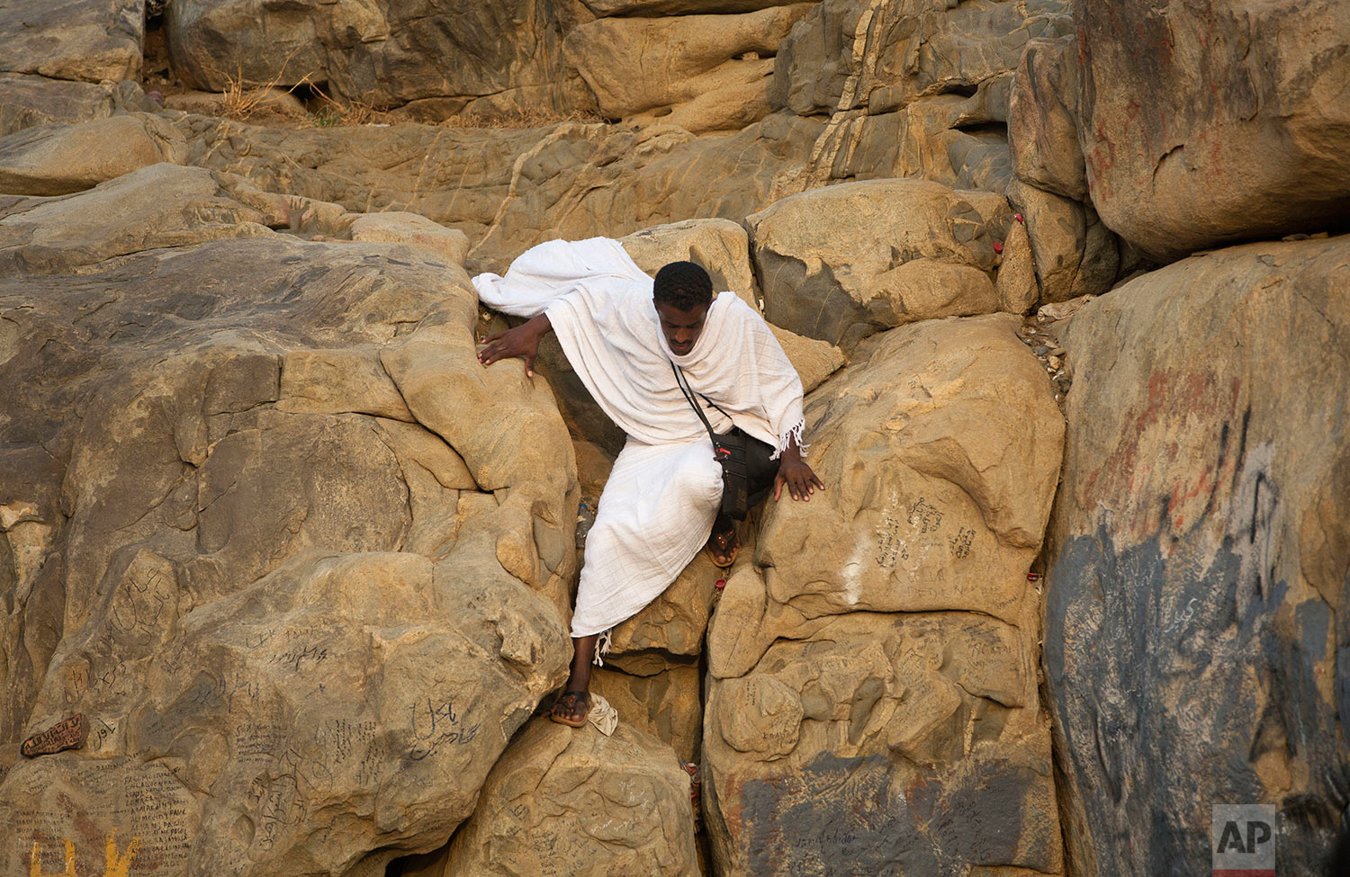  A pilgrim climbs Jabal Al Rahma holy mountain, or the mountain of forgiveness, at Arafat for the annual Muslim hajj pilgrimage outside the holy city of Mecca, Saudi Arabia, Thursday, Aug. 31, 2017. (AP Photo/Khalil Hamra) 