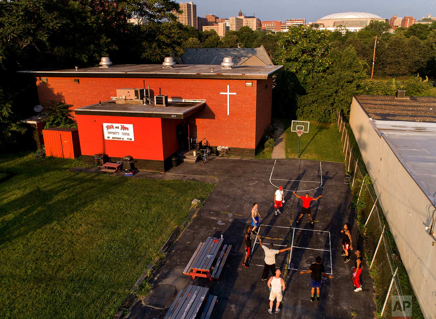  A group of teenagers and young men exercise outside the Faith and Hope Community Center in the South Side neighborhood just down the hill from Syracuse University's Carrier Dome, Monday, Aug. 21, 2017, in Syracuse, N.Y. Coach and mentor Arthur “Bobb