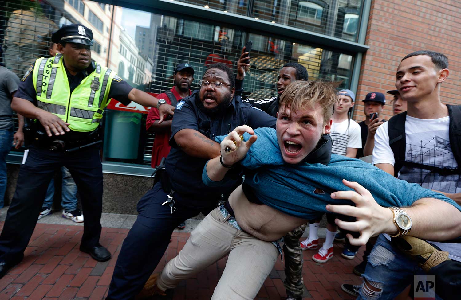  A counter-protester, part of a small group who remained on the street hours after a "Free Speech" rally was staged by conservative activists, scuffles with a security guard and police, Saturday, Aug. 19, 2017, in Boston. (AP Photo/Michael Dwyer) 