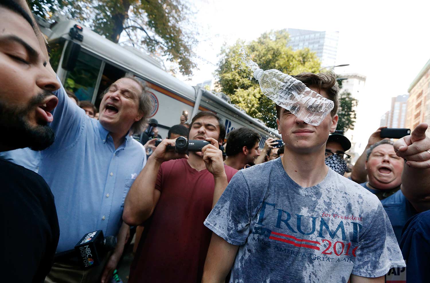  A man wearing a T-shirt bearing the name of President Donald Trump, right, is hit by a flying plastic bottle of water near a "Free Speech" rally staged by conservative activists, Saturday, Aug. 19, 2017, in Boston. Counterprotesters marched through 