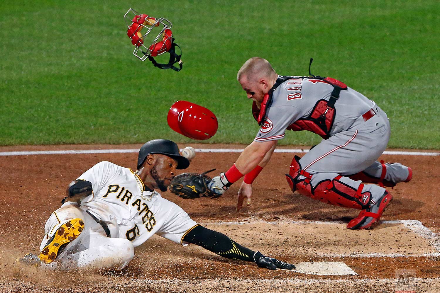  Cincinnati Reds catcher Tucker Barnhart drops the ball after tagging Pittsburgh Pirates' Starling Marte (6), who touches the plate to score the sixth inning of a baseball game in Pittsburgh, Wednesday, Aug. 2, 2017. (AP Photo/Gene J. Puskar) 