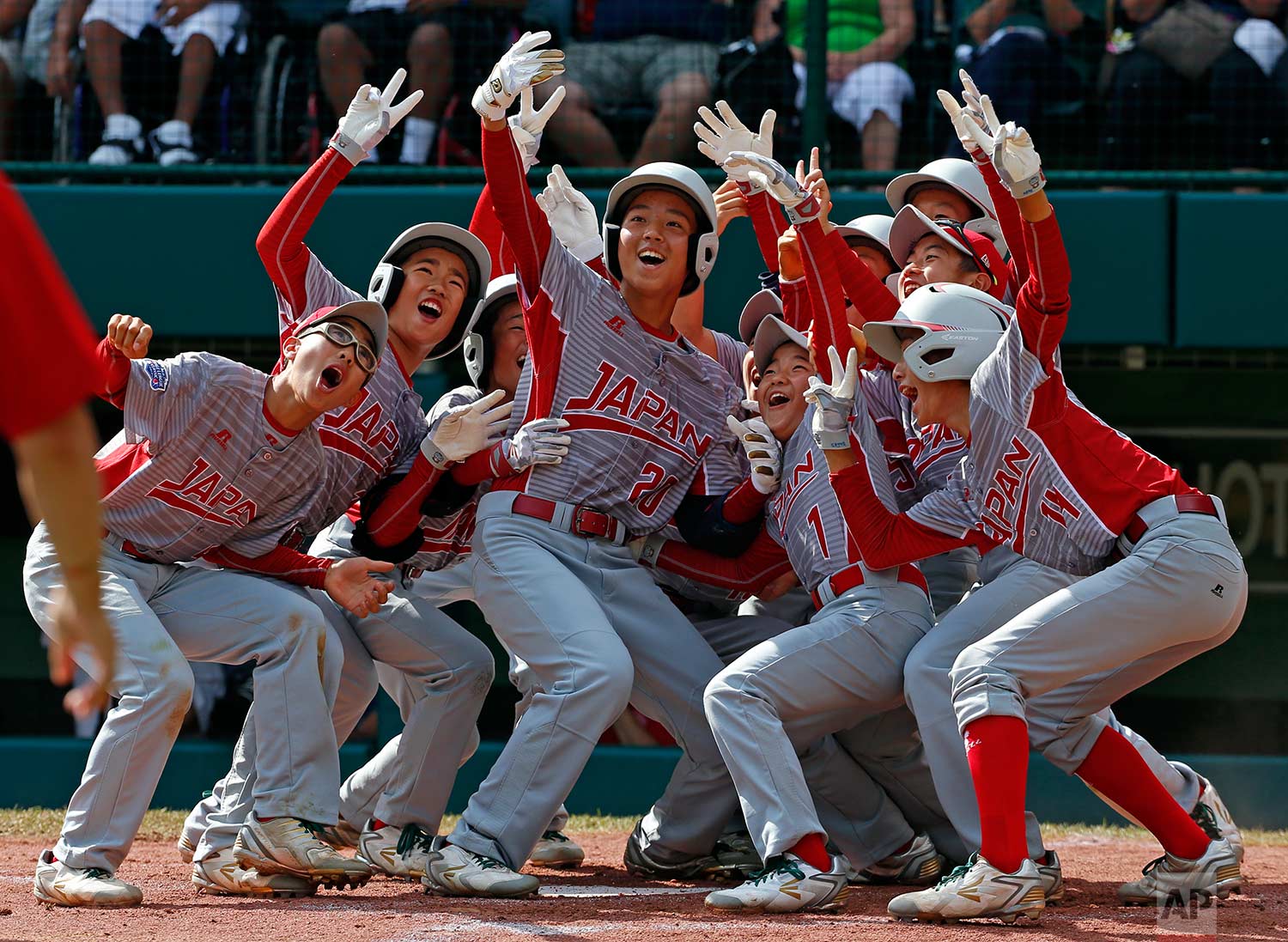  Tokyo, Japan's Natsuki Yajima (20) celebrates with teammates after hitting a two-run home run off White Rock, British Columbia pitcher Reece Ussleman in the third inning of an International baseball game at the Little League World Series tournament 