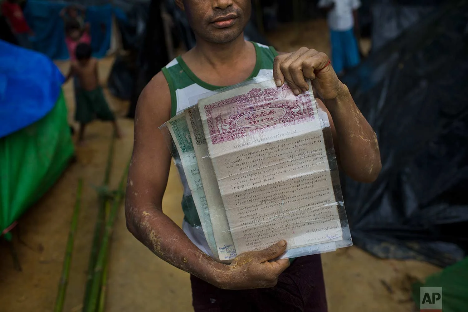 A Rohingya Nur Bashar, who recently crossed over the border from Myanmar into Bangladesh, holds documents of property and land his family owns in Myanmar, in Kutupalong, Bangladesh, Friday, Sept. 8, 2017. (AP Photo/Bernat Armangue)