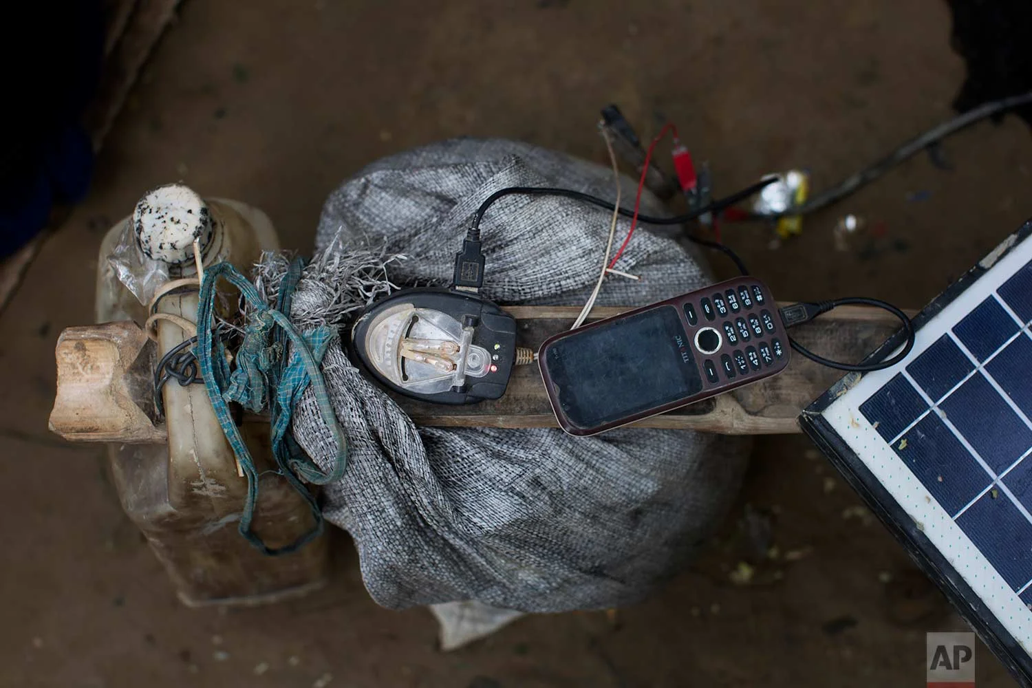 In this Thursday, Sept. 7, 2017, photo, a mobile phone is charged by a solar panel brought across the border by a Rohingya in Teknaf area, Bangladesh. (AP Photo/Bernat Armangue)