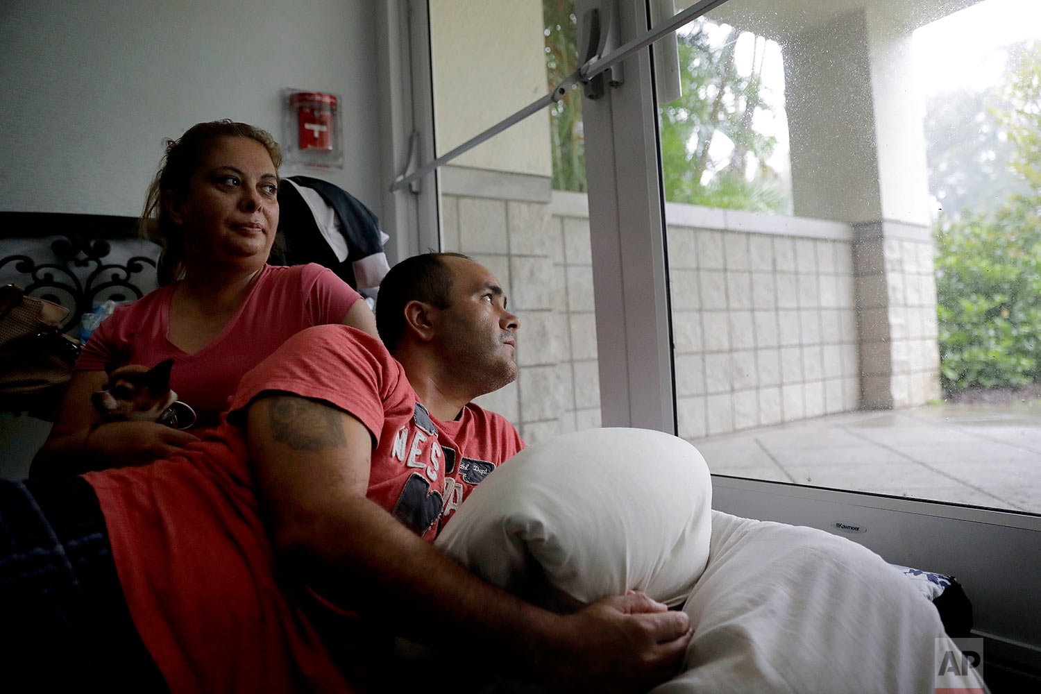  Javier Garcia, right, and his wife Marissa Soto sit with their neighbor's dog Ilito as they ride out Hurricane Irma in a shelter in Naples, Fla., Sunday, Sept. 10, 2017. (AP Photo/David Goldman) 