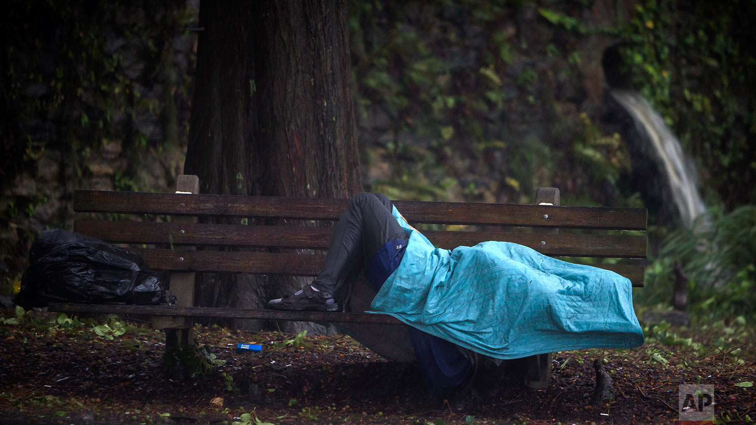  A homeless man lays on a bench on Historic River Street on Monday, Sept., 11, 2017, in Savannah, Ga., as Hurricane Irma starts to impact the area. (AP Photo/Stephen B. Morton) 