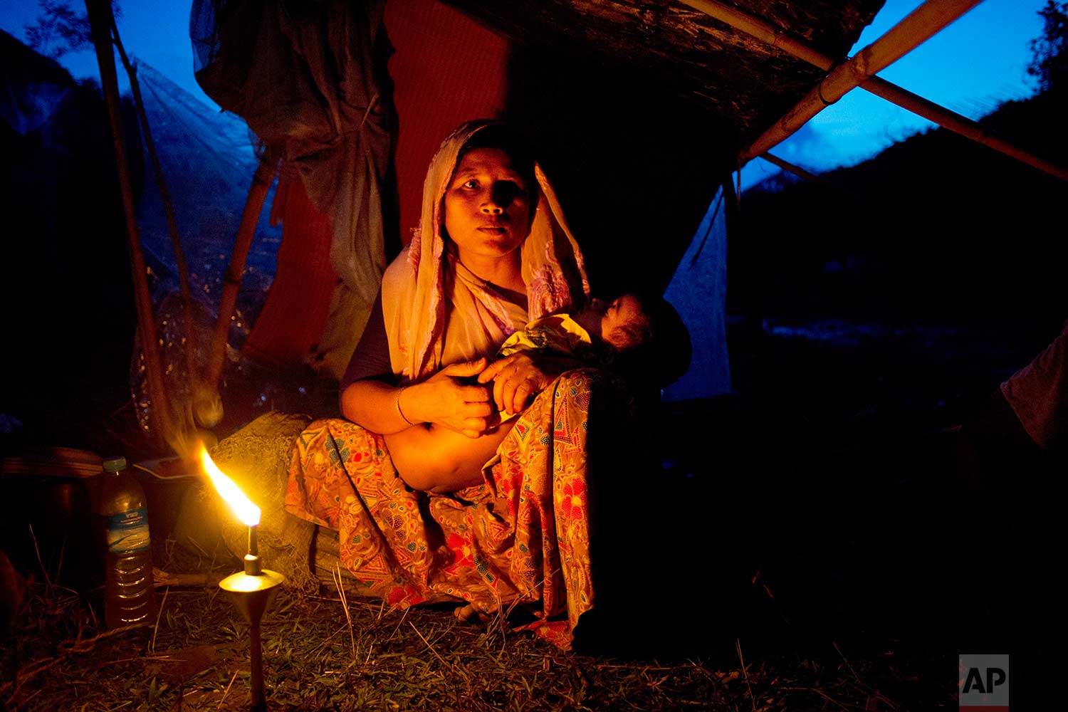  A Rohingya ethnic minority woman cradles her child at a temporary makeshift camp after crossing over from Myanmar into the Bangladesh side of the border, near Cox's Bazar's Gundum area, Saturday, Sept. 2, 2017. U.N. spokesman Stephane Dujarric told 