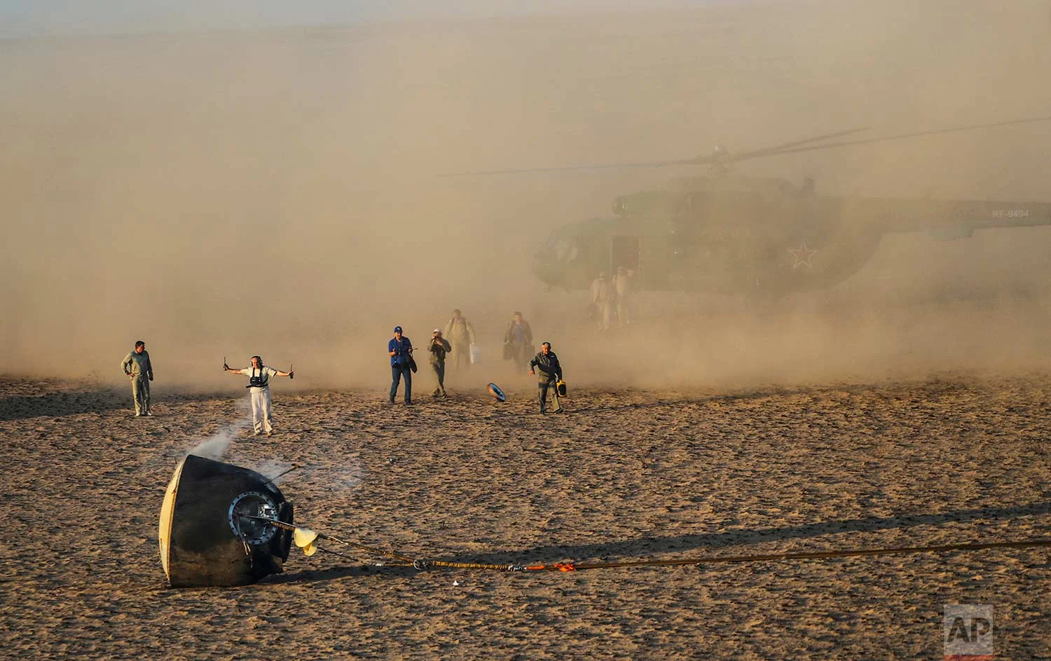 A search and rescue team works on the site of landing of Russian Soyuz MS-04 space capsule in a remote area outside the town of Dzhezkazgan, Kazakhstan, Sunday, Sept. 3, 2017. The Soyuz capsule carrying Astronauts Peggy Whitson and Jack Fischer of NASA and Fyodor Yurchikhin of the Russian space agency Roscosmos safely returned to Earth in the Kazakh steppe. (Sergei Ilnitsky/Pool via AP)