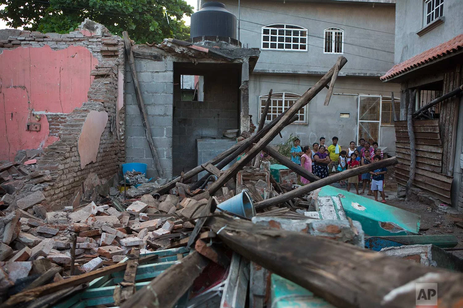 Neighbors look at a home destroyed by a massive earthquake, in Juchitan, Oaxaca state, Mexico, Saturday, Sept. 9, 2017. The 8.1 quake off the southern Pacific coast just before midnight Thursday toppled hundreds of buildings in several states. Hardest-hit was Juchitan, where a third of the city's homes collapsed or were uninhabitable. (AP Photo/Rebecca Blackwell)
