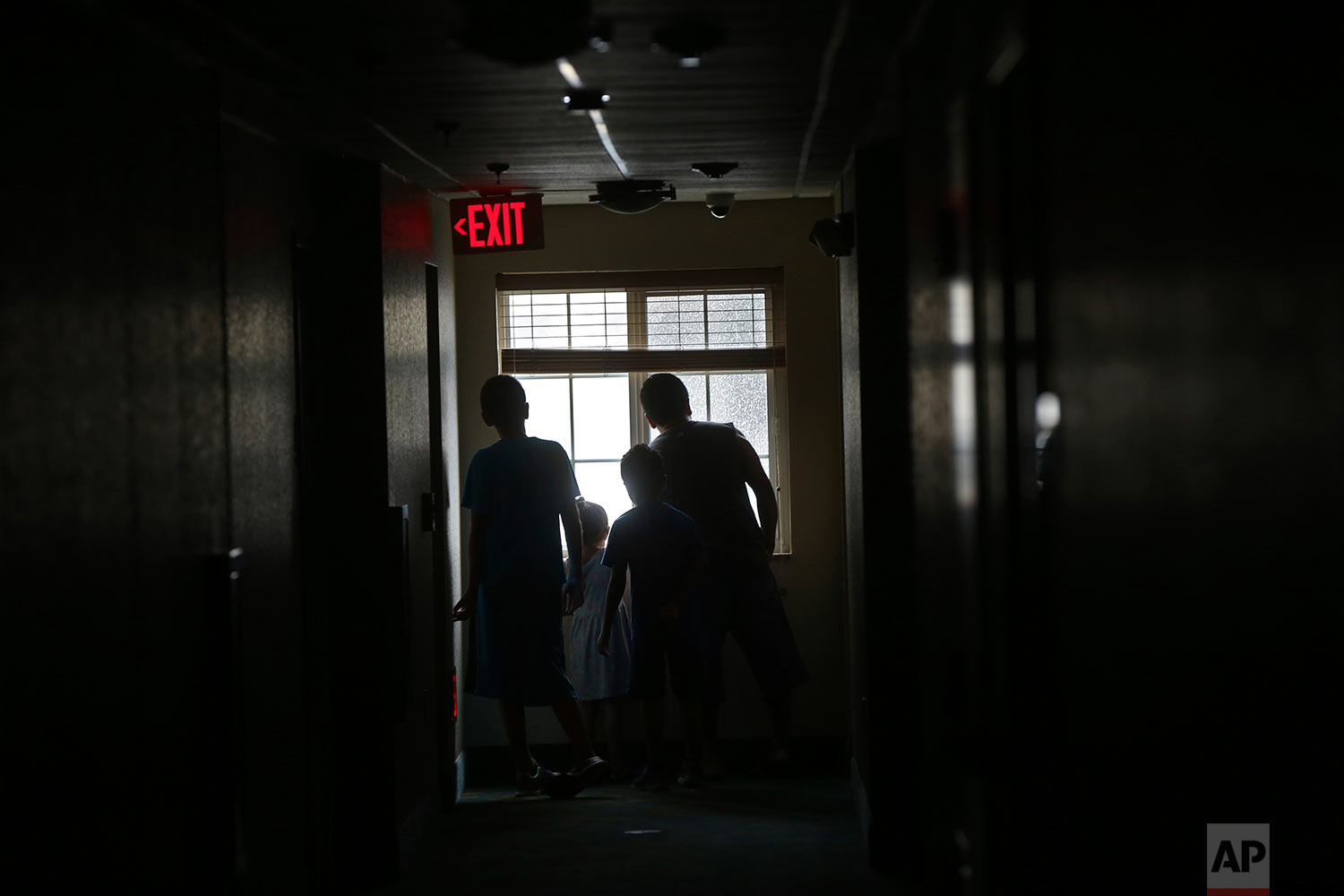  Guests of the Candlewood Suites look out a darkened hall window, after the hotel lost power, as Hurricane Irma arrives, in Fort Myers, Fla., Sunday, Sept. 10, 2017. (AP Photo/Gerald Herbert) 