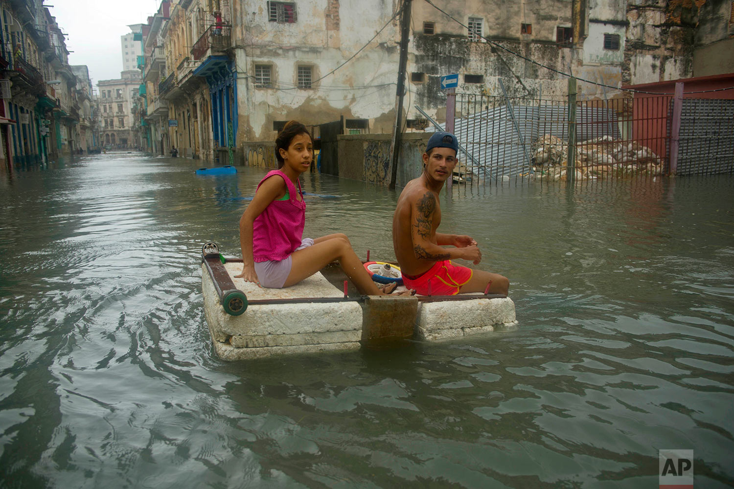  A couple floats down a flooded street in Havana atop a large piece of styrofoam, after the passing of Hurricane Irma in Cuba, Sunday, Sept. 10, 2017. The powerful storm ripped roofs off houses, collapsed buildings and flooded hundreds of miles of co