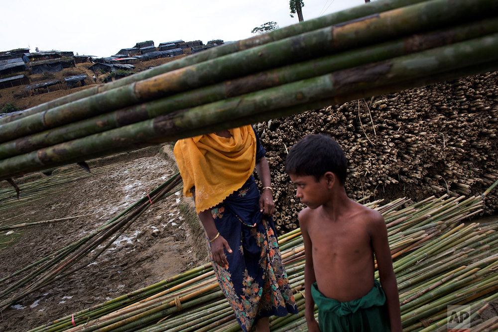  A Rohingya boy stands near bamboo poles used for building tents at a new refugee camp in Ukhia, Bangladesh, Saturday, Sept. 9, 2017. (AP Photo/Bernat Armangue) 