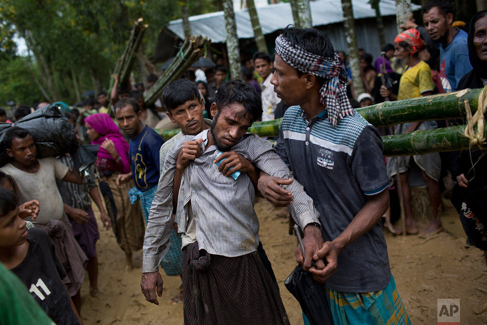  Kifawet Ullah is helped by other newly arrived Rohingya after he collapsed while waiting to have his token validated in order to collect a bag of rice distributed by aid agencies in Kutupalong, Bangladesh, Saturday, Sept. 9, 2017. (AP Photo/Bernat A