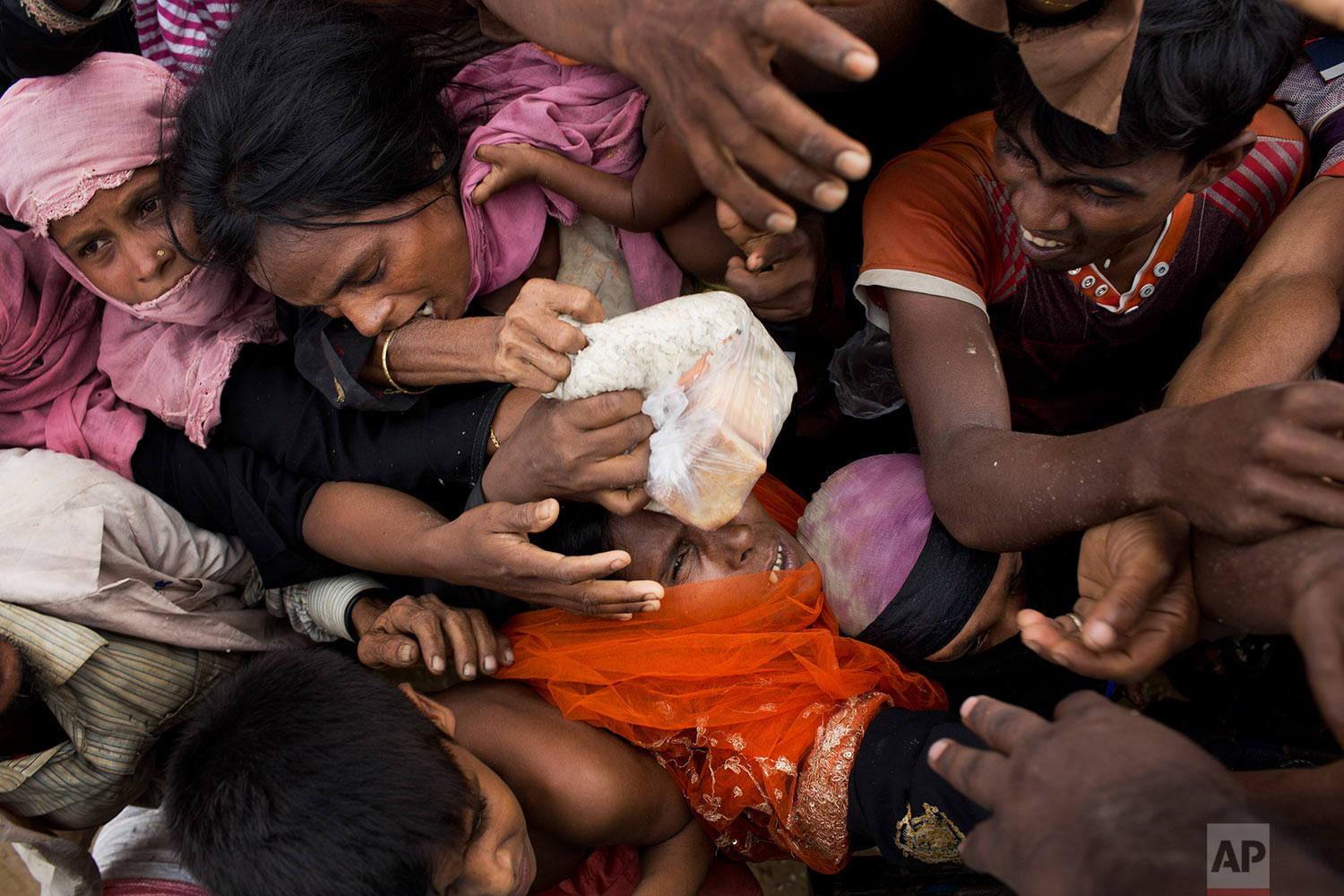  Rohingya Muslims, newly arrived from Myanmar, scuffle for puffed rice food rations donated by local volunteers in Kutupalong, Bangladesh, Saturday, Sept. 9, 2017. (AP Photo/Bernat Armangue) 