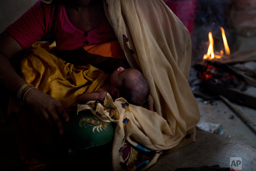  In this Thursday, Sept. 7, 2017 photo, 25-year-old Rohingya Muslim woman Zahida Begum cradles her few-hours-old son who she gave birth to alone in the toilet outside the room, at Kutupalong refugee camp, Bangladesh. Begum had crossed into Bangladesh