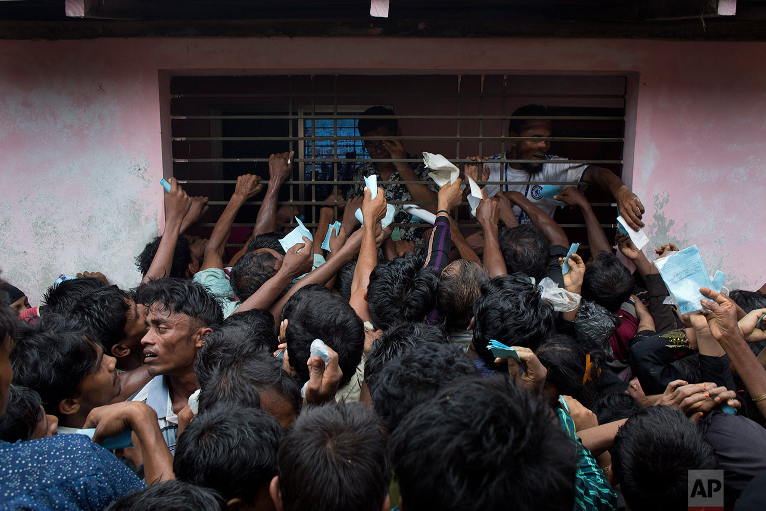  Newly arrived Rohingya try to get their tokens validated in order to collect a bag of rice distributed by aid agencies in Kutupalong, Bangladesh, Saturday, Sept. 9, 2017. (AP Photo/Bernat Armangue) 