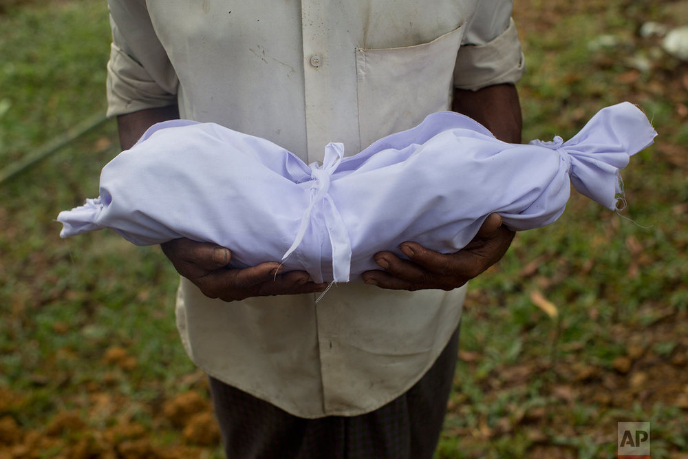  A Rohingya man holds the body of a two-day-old baby before his burial at Kutupalong's refugee camp cemetery, Sept. 8, 2017,  Bangladesh. On Friday, two infants were interred there. A six- day old baby, who was born on the road as his family escaped,