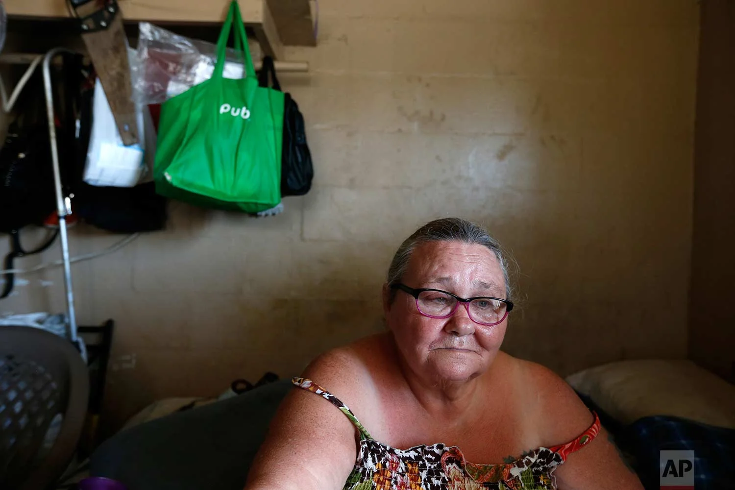 In this Sept. 12, 2017 photo, Pattie Deeley, who has asthma and other health problems which keep her on supplemental oxygen, sits in her small cinderblock apartment during a multi-day power failure in the aftermath of Hurricane Irma, in Immokalee, Fla. Unable to cook after the storm, Deeley said she had to spend extra money buying meals after Irma. (AP Photo/Gerald Herbert)