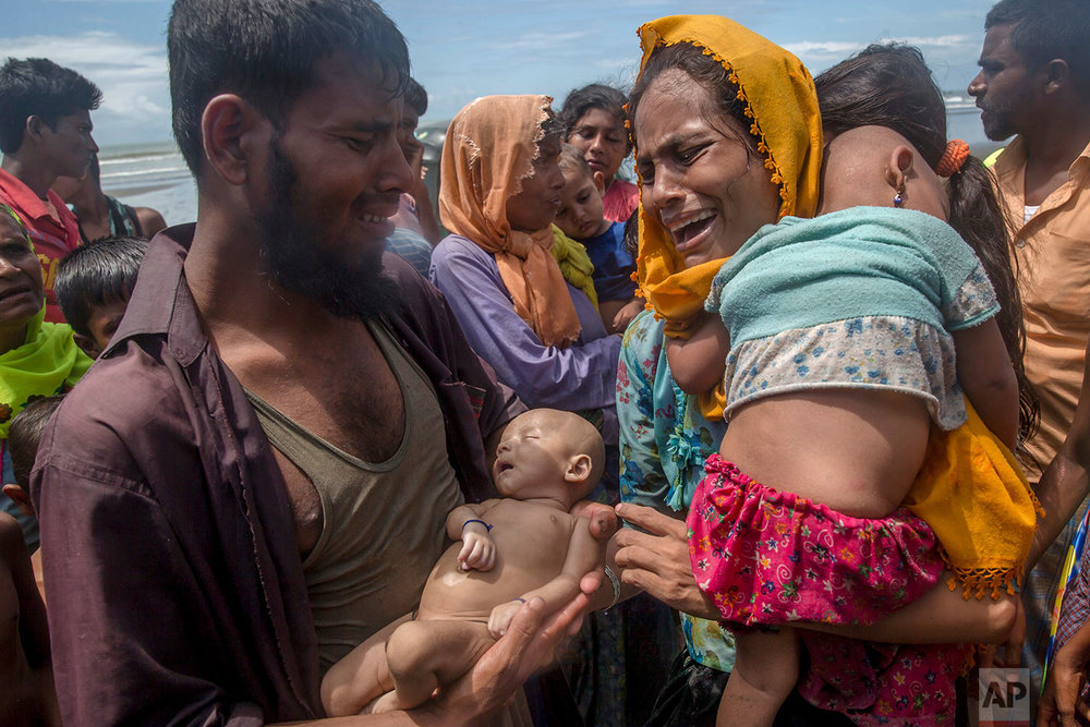  A Rohingya Muslim man Naseer Ud Din holds his infant son Abdul Masood, who drowned when the boat they were traveling in capsized just before reaching the shore, as his wife Hanida Begum cries upon reaching the Bay of Bengal shore in Shah Porir Dwip,