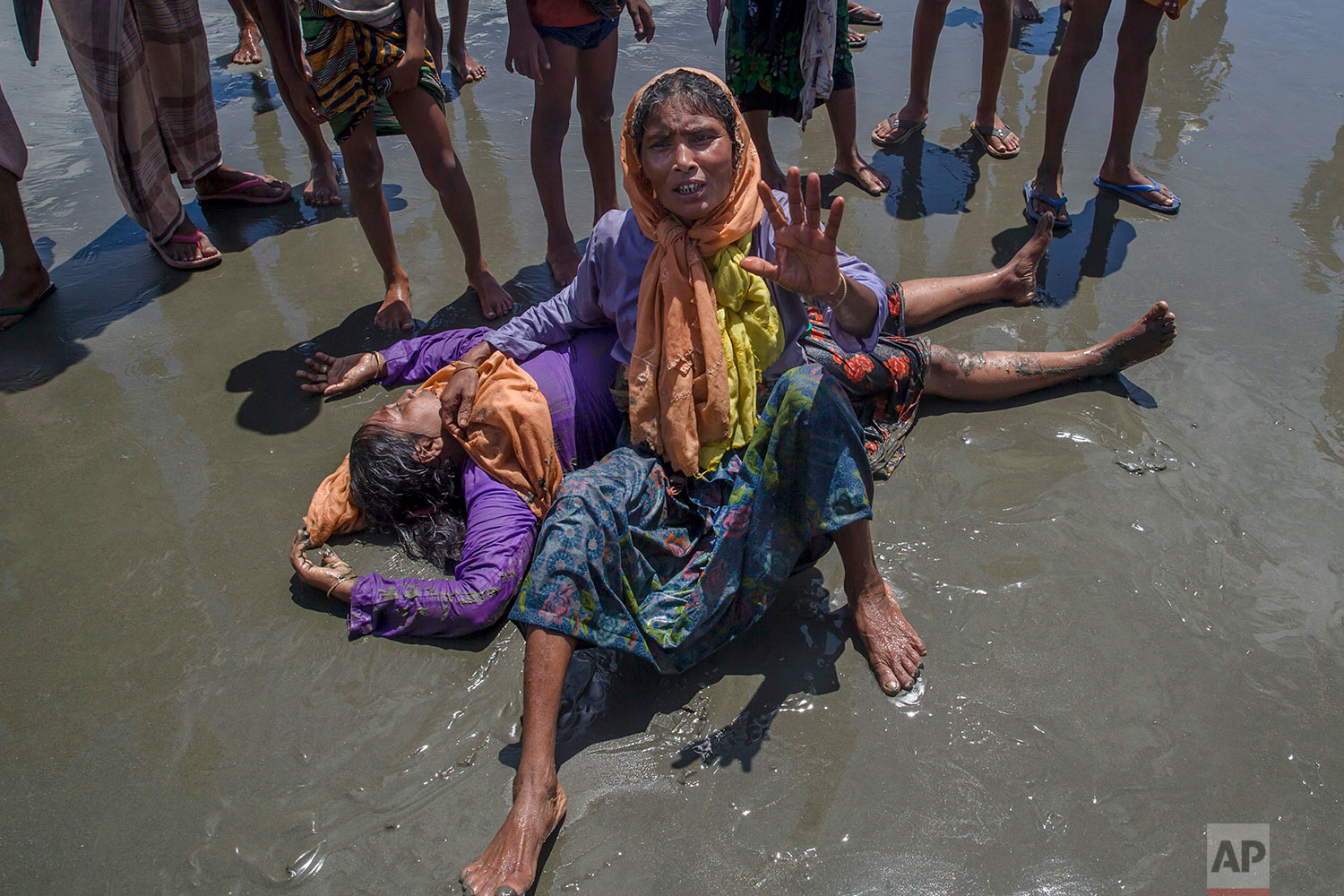 A Rohingya Muslim woman, who crossed over from Myanmar into Bangladesh, shouts for help as a relative lies unconscious after the boat they were traveling in capsized minutes before reaching shore at Shah Porir Dwip, Bangladesh, Thursday, Sept. 14, 2