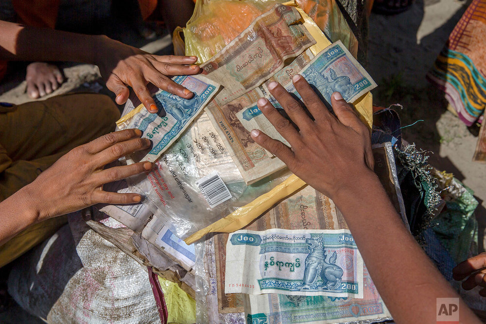  Rohingya Muslim boys, who crossed over from Myanmar into Bangladesh, dry their Myanmarese currency after arriving by boat at Shah Porir Dwip, Bangladesh, Thursday, Sept. 14, 2017. (AP Photo/Dar Yasin) 