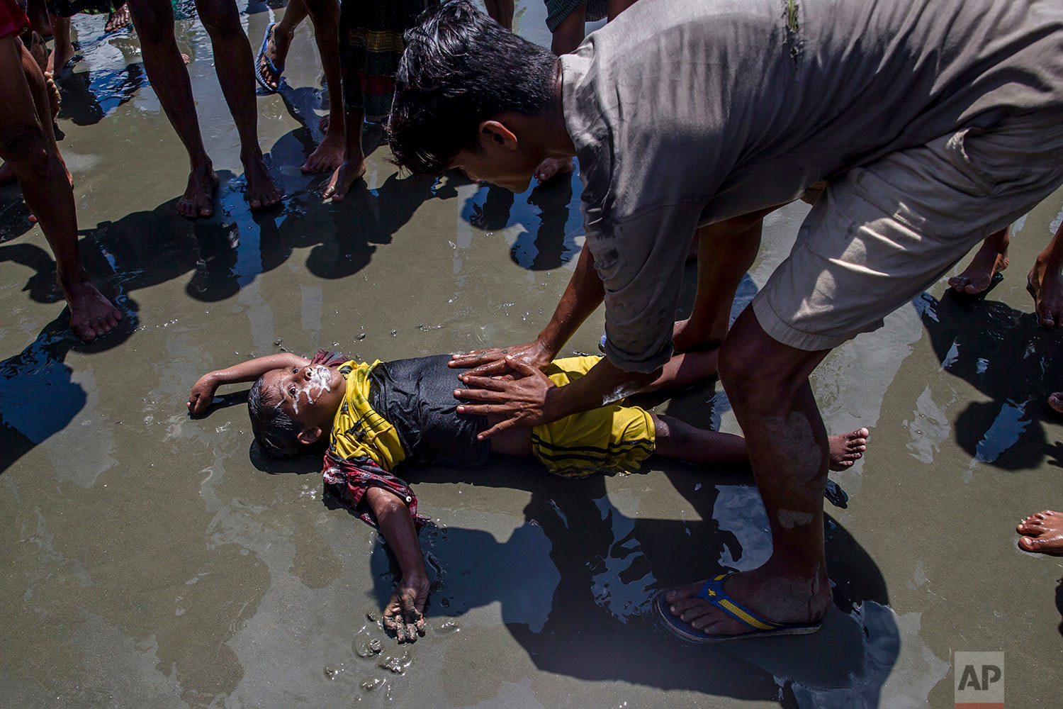  A Rohingya Muslim boy froths from the mouth as a man successfully tries to revive him after the boat he was traveling in capsized just before reaching shore at Shah Porir Dwip, Bangladesh, Thursday, Sept. 14, 2017.  (AP Photo/Dar Yasin) 