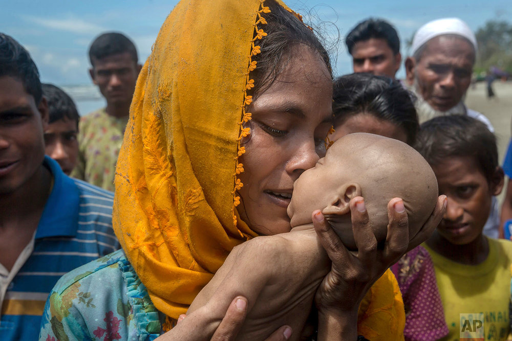  A Rohingya Muslim woman Hanida Begum, who crossed over from Myanmar into Bangladesh, kisses her infant son Abdul Masood who died when the boat they were traveling in capsized just before reaching the shore of the Bay of Bengal, in Shah Porir Dwip, B