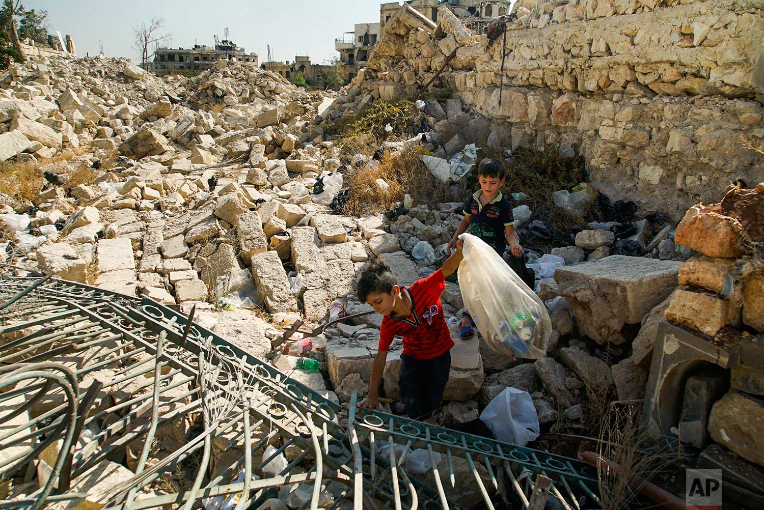 Young boys collect cans amid the rubble in Aleppo, Syria, on Tuesday, Sept. 12, 2017. The recapture of eastern Aleppo in December 2016, one of the deadliest episodes of the Syrian civil war, was a landmark victory for Assad's forces in the conflict,
