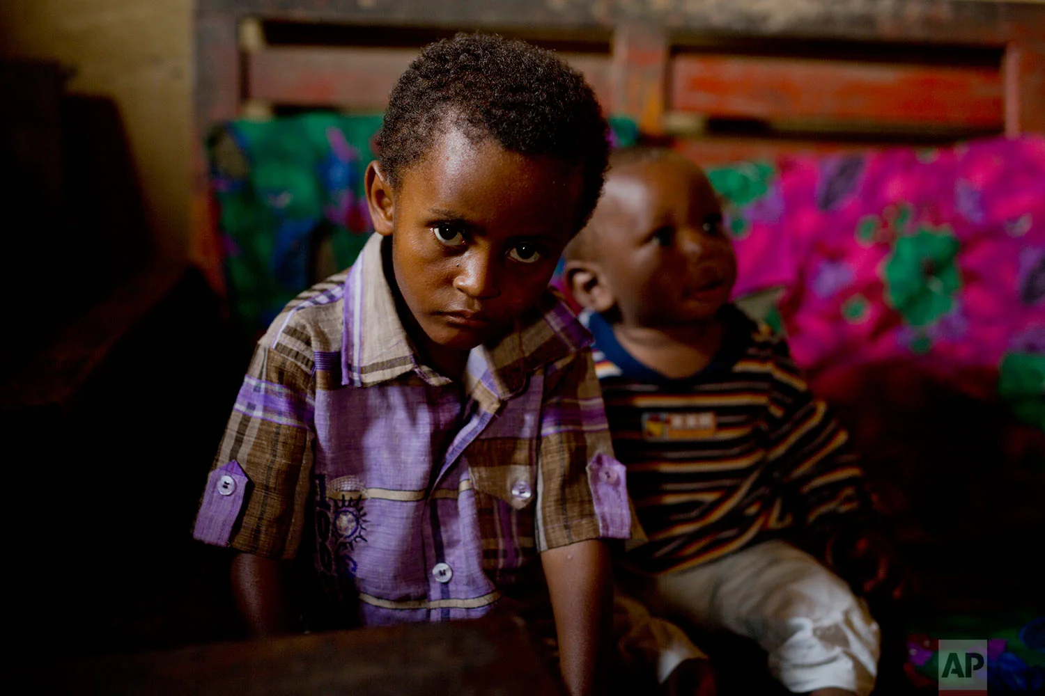 In this photo taken Aug. 10, 2016, 8-year-old Michael sits at his mother's house in the Congo Ituri province capital Bunia. Michael has never met his father, and only knows that he was a foreigner from one of the peacekeeping missions in the country. (AP Photo/Jerome Delay) 