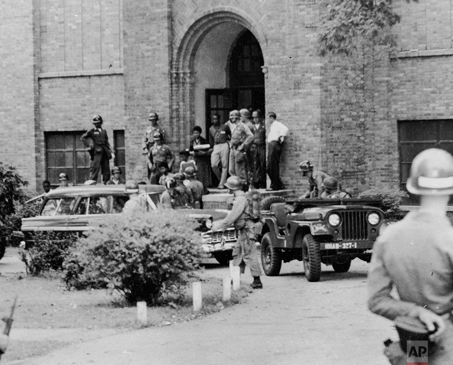Nine black students leave Central High School in Little Rock, Ark., after classes, Sept. 25, 1957. They are being escorted from a side door by troops of the 101st Airborne Division. (AP Photo)