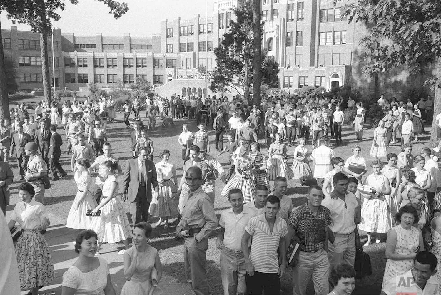 In this Sept. 1957 photo, students are watched by soldiers and reporters as they leave Little Rock's Central High School in Little Rock, Ark. (AP Photo/Will Counts)