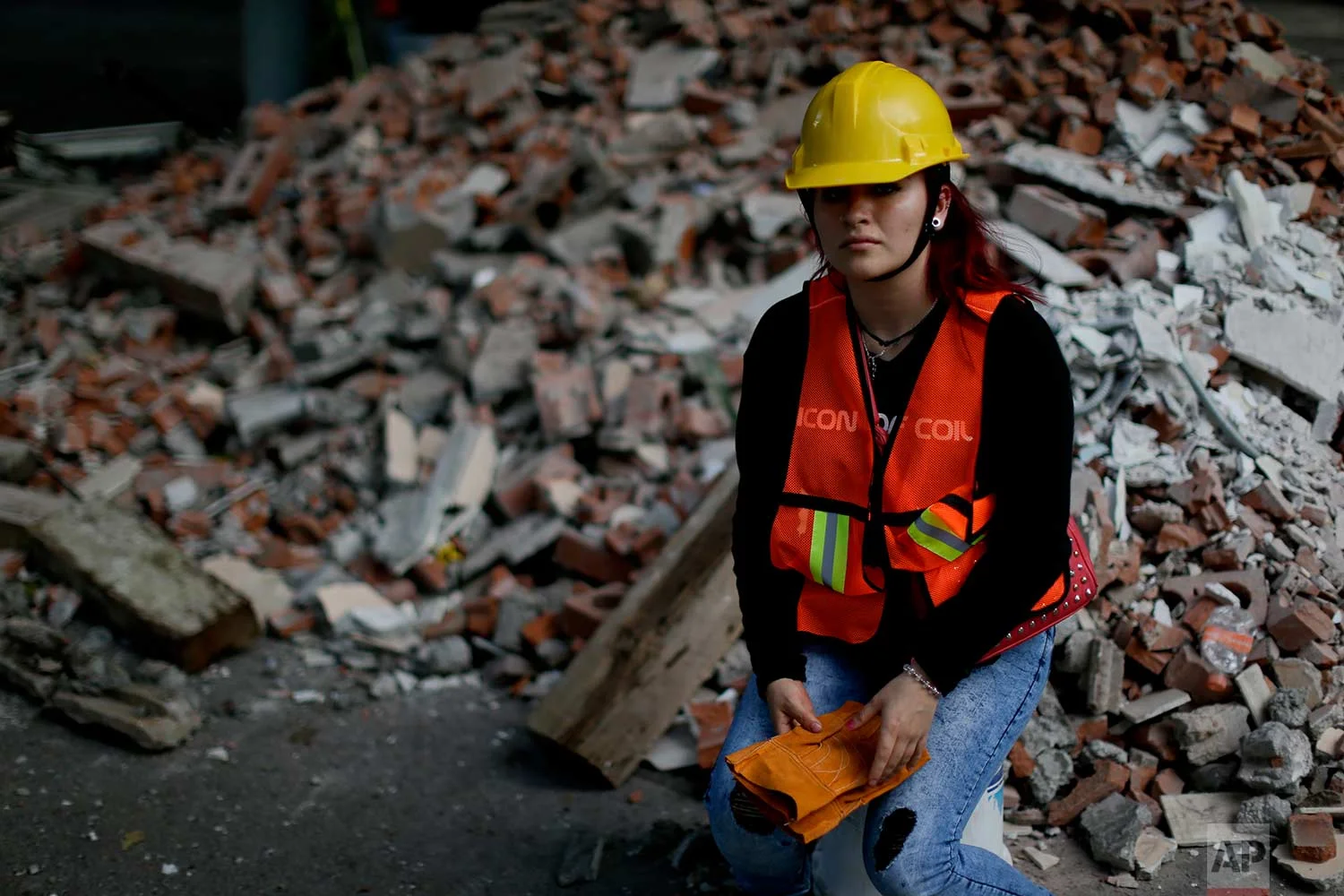 Frida Islas Rueda, 22-year-old student, poses for a picture near debris from a damaged building after an earthquake, Sept. 22, 2017, in Mexico City. (AP Photo/Natacha Pisarenko)