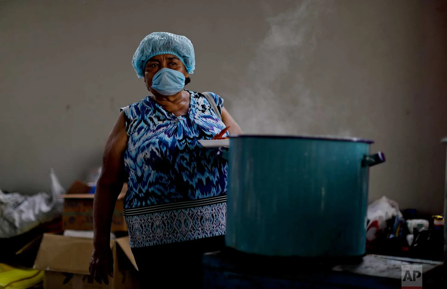Volunteer Abigail Carino Marin cooks for homeless people affected by the earthquake, Sept. 23, 2017, Atzala, Mexico. (AP Photo/Natacha Pisarenko)