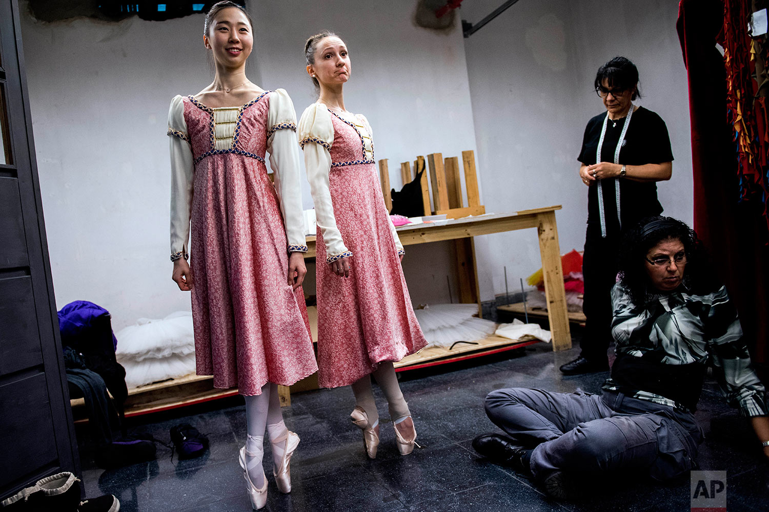  In this Wednesday, Sept. 6, 2017 photo, ballet dancers Eunsil Kim, left, and Paula Penachio try on their dresses at the costume workshop at the Adela Reta Auditorium in Montevideo, Uruguay. (AP Photo/Matilde Campodonico) 