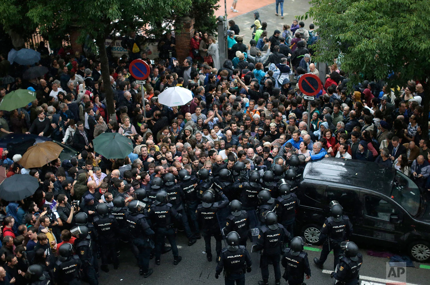 Spanish National Police prevents people from entering a voting site at a school assigned to be a polling station by the Catalan government in Barcelona, Spain, Sunday, 1 Oct. 2017. (AP Photo/Emilio Morenatti)