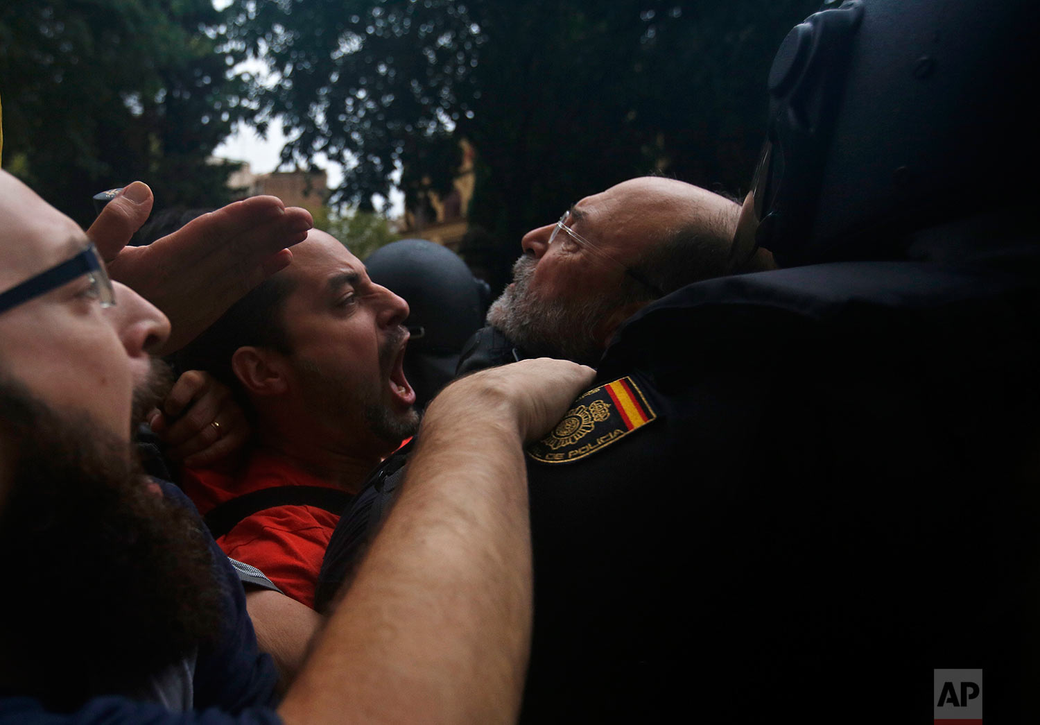  Spanish National Police pushes away Pro-referendum supporters outside the Ramon Llull school assigned to be a polling station by the Catalan government in Barcelona, Spain, early Sunday, Oct. 1, 2017. Catalan pro-referendum supporters vowed to ignor